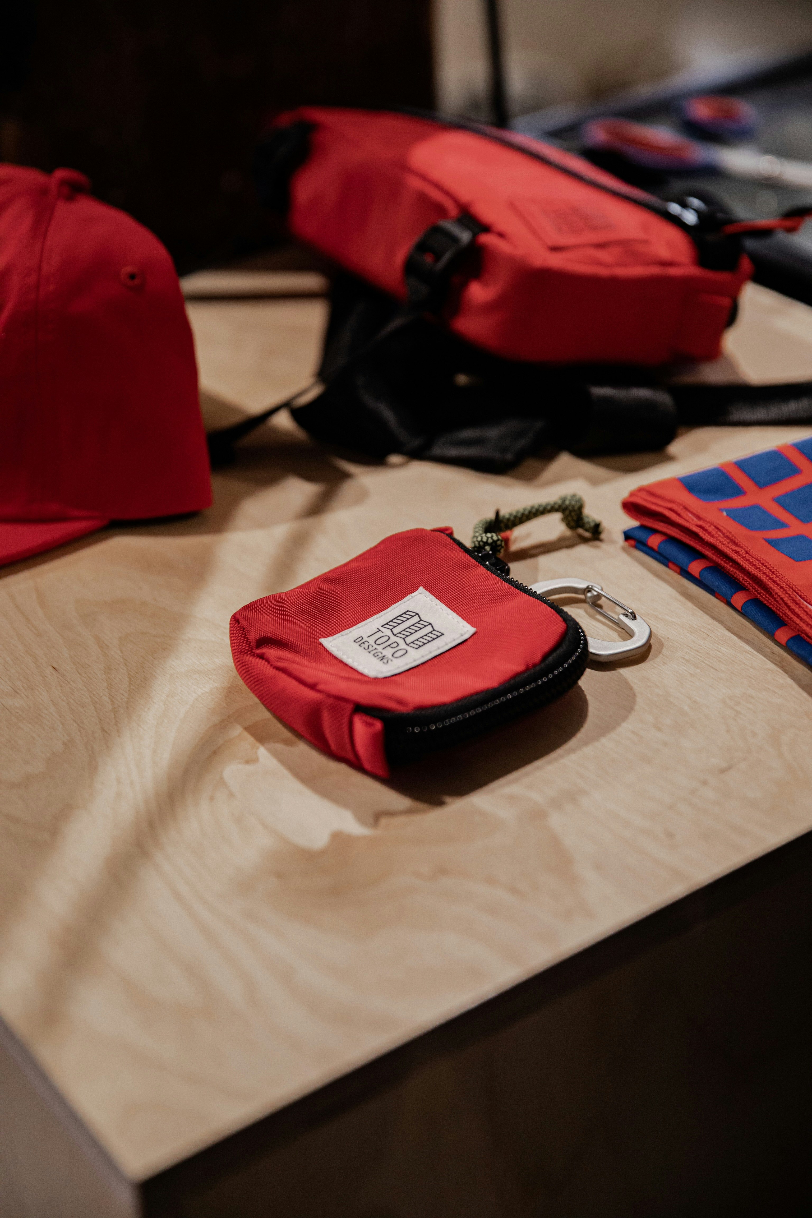 red and black leather sling bag on white textile